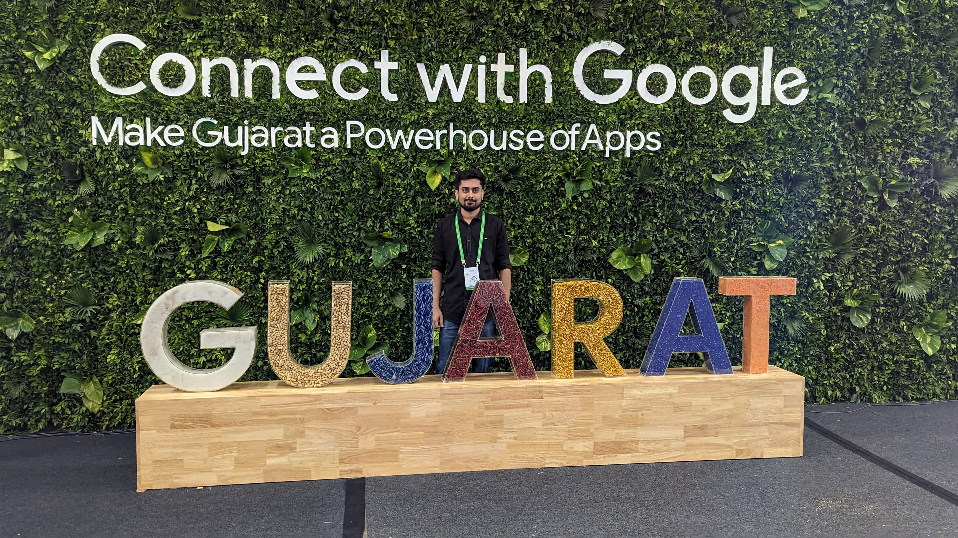 Ronak standing behind giant GUJARAT letters at the Connect with Google event wall.